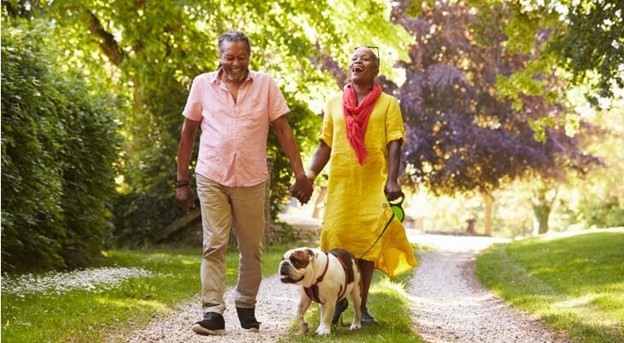 bright day with couple walking on a road with the bulldog laughing 